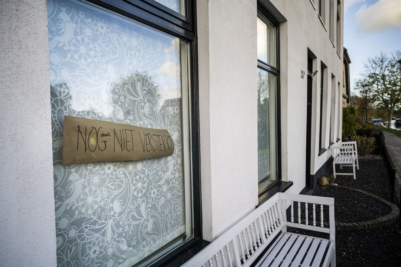 Voor het raam van een huis in het Groningse Garrelsweer hangt een bordje met de tekst: 'Nog (steeds) niet versterkt'.