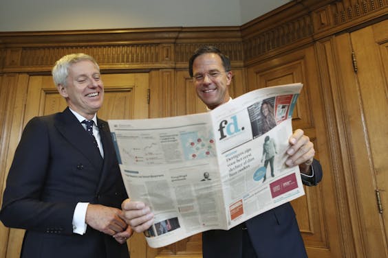 Premier Mark Rutte neemt het vernieuwde FD in ontvangst in het torentje, uit handen van hoofdredacteur Jan Bonjer.