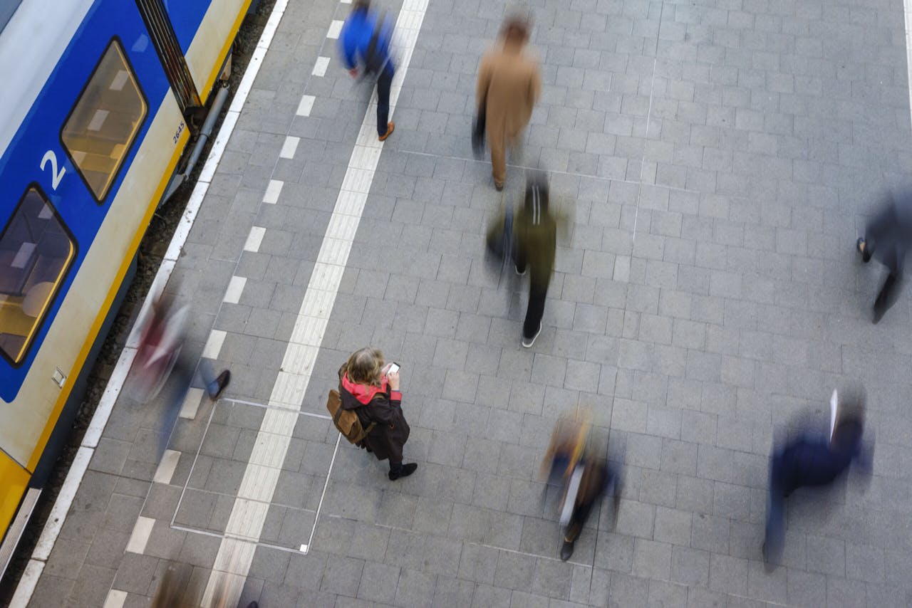 Reizigers lopen op het station Den Haag Centraal verplaatsen zich op een doordeweekse ochtend. Wie straks met een coronapaspoort op zak wil reizen, is afhankelijk van de apps van Google en Apple.