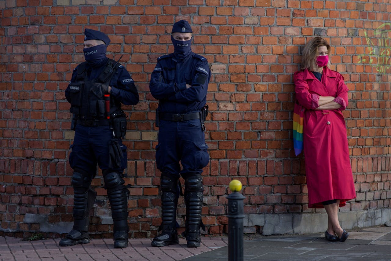 Agenten van de Poolse oproerpolitie houden zaterdag bij protesten in Warschau tegen beperking van het recht op abortus, een oogje in het zeil bij een demonstrant.
