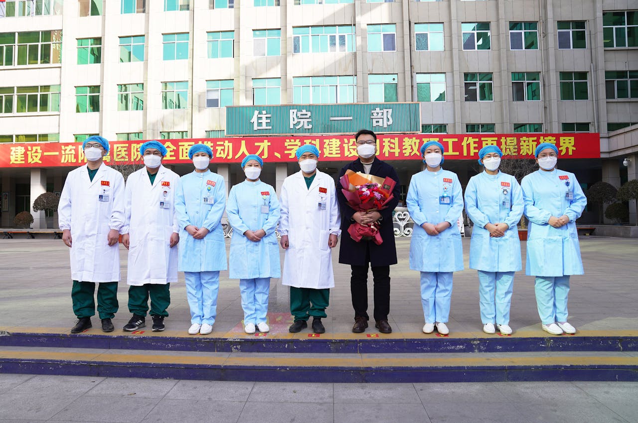 Een coronapatiënt uit Zouping City in China is met zijn medische team op de foto gezet. Zijn genezing wordt zo wereldkundig gemaakt, en dat was ook nog een bos bloemen waard.