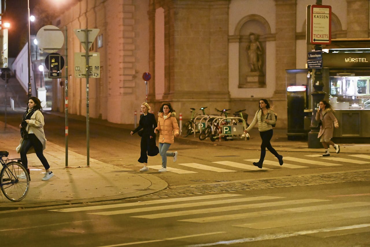 Rennende mensen nabij de Weense Staatsopera, maandagnacht tijdens beschietingen in de Oostenrijkse hoofdstad.