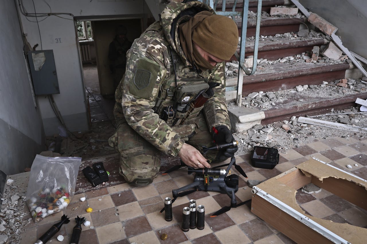 Een Oekraïense militair laadt een drone met granaten, in de stad Bachmoet.