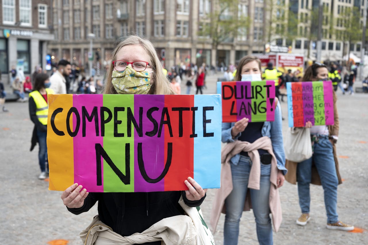 Demonstranten op de Dam eisen snellere uitbetaling van de schadevergoedingen van gedupeerden in de toeslagenaffaire.