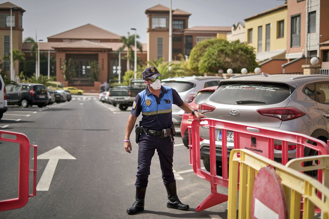 Een Spaanse agent sluit de weg af naar het in quarantaine geplaatste hotel op Tenerife.