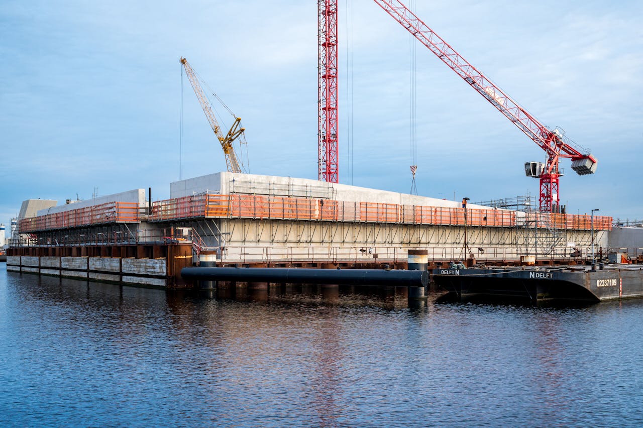 De bouw van het nieuwe sluizencomplex in IJmuiden, enige tijd geleden, gezien vanaf het water. De grootste zeesluis ter wereld wordt woensdag officieel geopend.