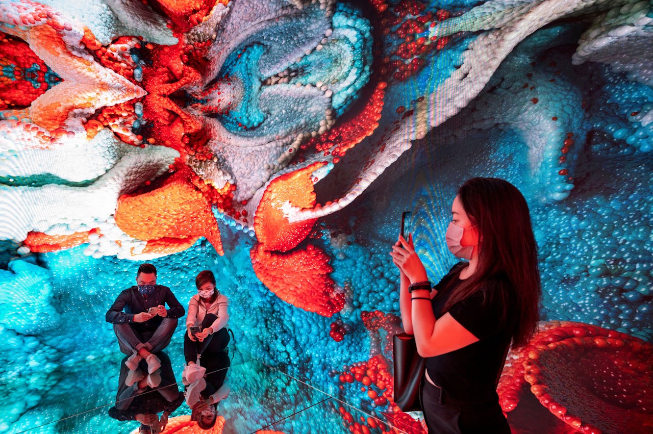 Een bezoeker van de digitale-kunstbeurs in Hongkong fotografeert een kunstinstallatie. Handelaren denken dat NFT's kunnen uitgroeien tot meer dan een speculatiemiddel en dat digitale kunst ook in virtuele huizen wordt 'opgehangen'.