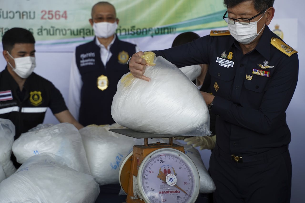 Directeur-generaal Patchara Anuntasilpa van de Thaise douane (r) toont in beslag genomen crystal meth met een straatwaarde van omgerekend $3,4 mln.
