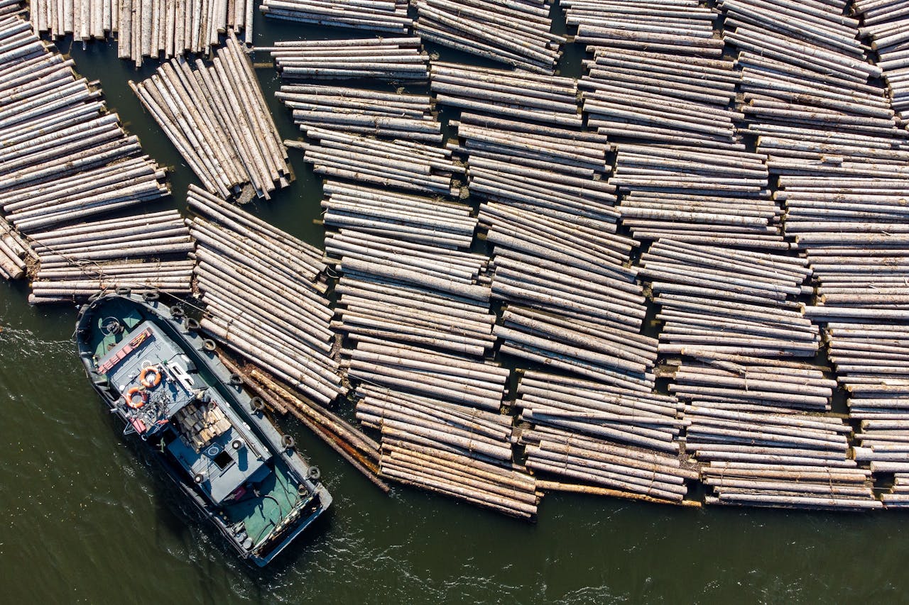 Een boot afgemeerd langs een houten vlot op de Russische Yenisei-rivier bij een houtverwerkingsfabriek in Lesosibirsk. Rowood zegt na invoering van de sancties de import van Russisch hout te hebben gestaakt.