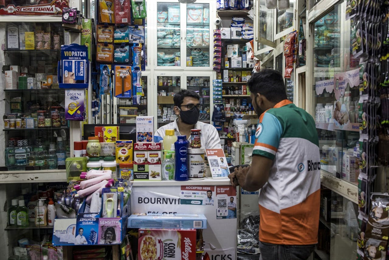 Een medewerker van BharatPe probeert een winkeleigenaar in New Delhi te overtuigen van de voordelen van een universeel systeem met QR-codes, dat klanten in staat stelt met een betaalapp naar keuze te betalen.