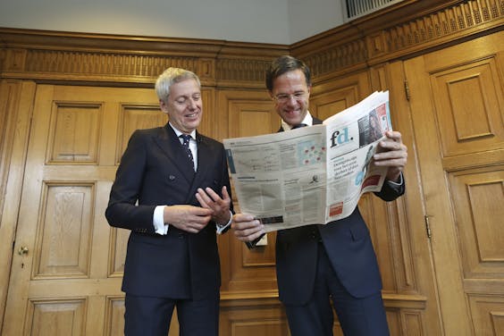 Premier Mark Rutte neemt het vernieuwde FD in ontvangst in het torentje, uit handen van hoofdredacteur Jan Bonjer.