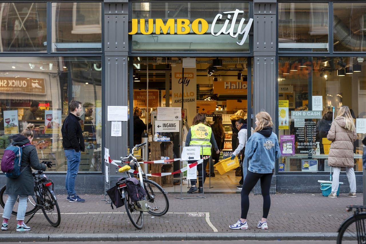 Een wachtrij door het deurbeleid om naar binnen te gaan bij het Jumbo city filiaal op de Ferdinand Bolstraat in Amsterdam.