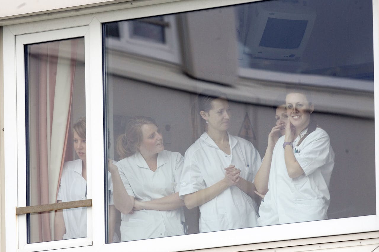 Verpleegkundigen kijken in 2007 vanuit het Bronovo, jarenlang bekend als het vaste ziekenhuis van de koninklijke familie, naar de toegestroomde pers. Toenmalig prinses Máxima was er opgenomen in afwachting van de geboorte van haar derde kind.