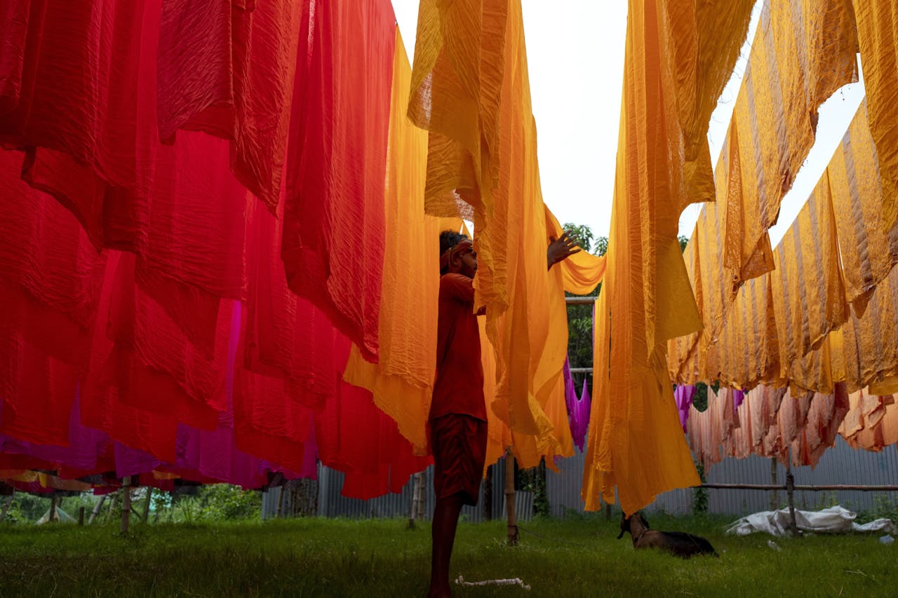 Textiel hangt te drogen in Bangladesh, waar de instorting van een kledingfabriek tien jaar geleden leidde tot meer aandacht voor maatschappelijk verantwoord ondernemen.