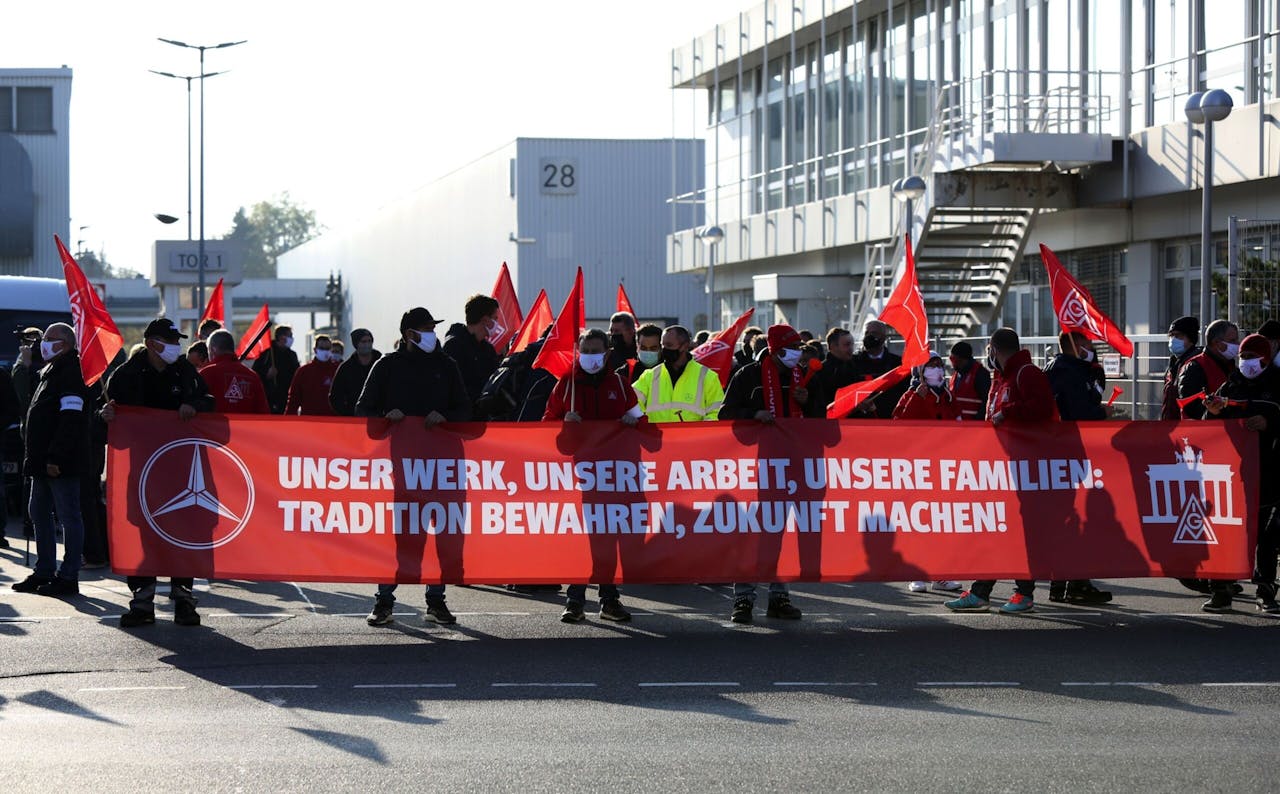 Werknemers en leden van de vakbond IG Metall demonstreren bij het fabrieksterrein van Mercedes-Benz, naar aanleiding van het vertrek van een topman naar concurrent Tesla.