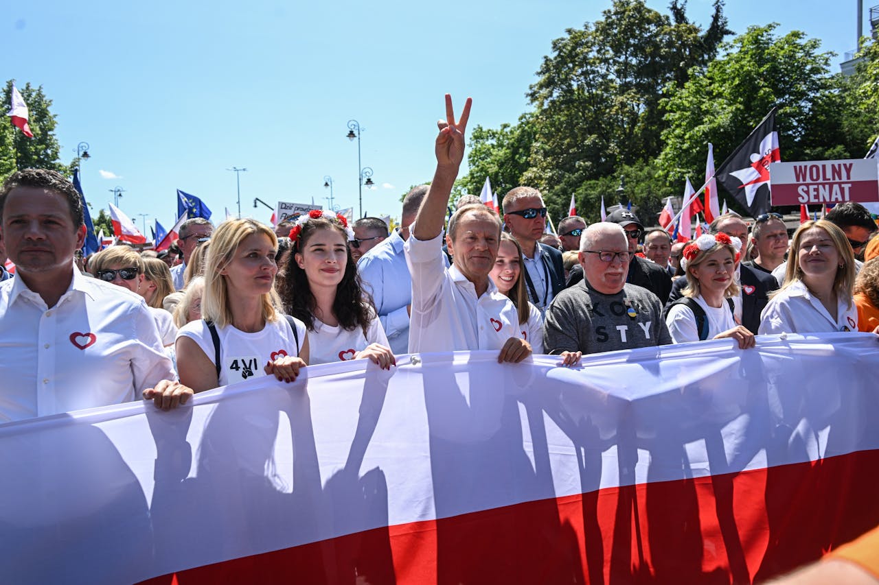 Donald Tusk (met vingers in de lucht) tijdens een grote demonstratie op 4 juni in Warschau.