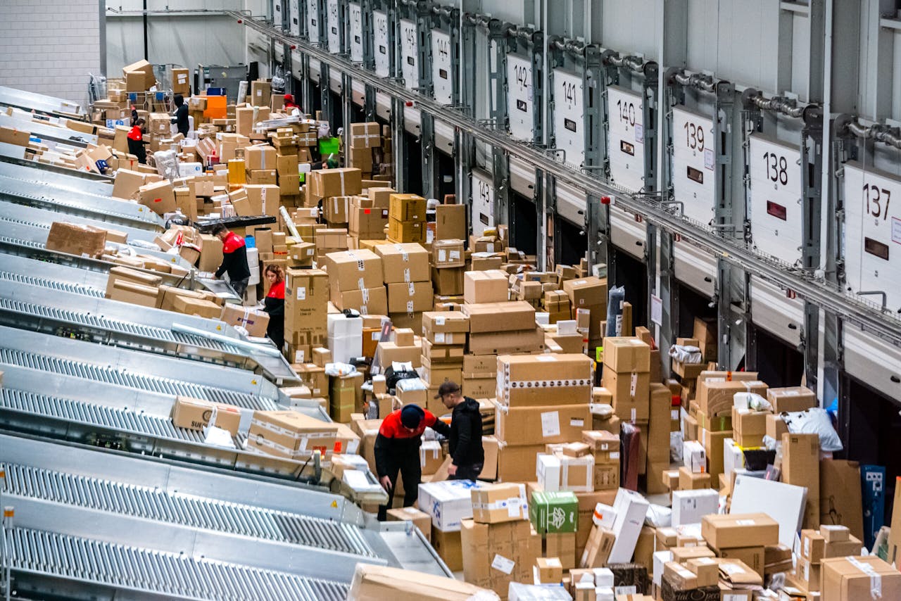 Medewerkers van pakketdienst DPD sorteren pakketjes in het pakkettensorteercentrum in december, de drukste maand van het jaar. Webwinkels kunnen de bestellingen sinds de coronacrisis nauwelijks bijbenen, zeggen experts.