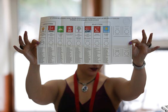 Een vrouw houdt een stembiljet op in een stembureau in Istanboel. Daar is het tellen inmiddels begonnen.