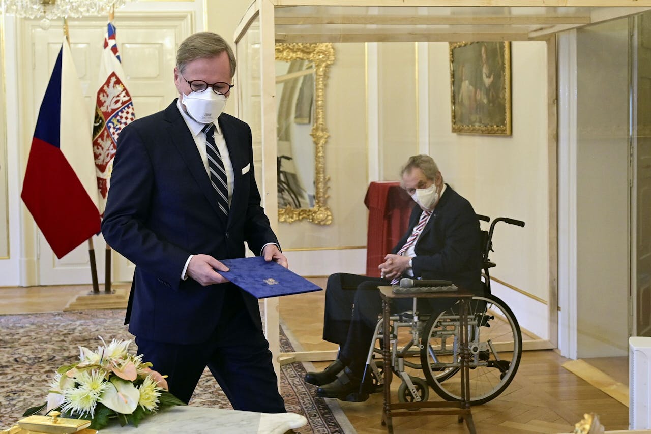 Premier Fiala (l) en president Zeman. Die zit in een glazen hokje om hem te beschermen tegen het coronavirus. Zeman heeft een slechte gezondheid.