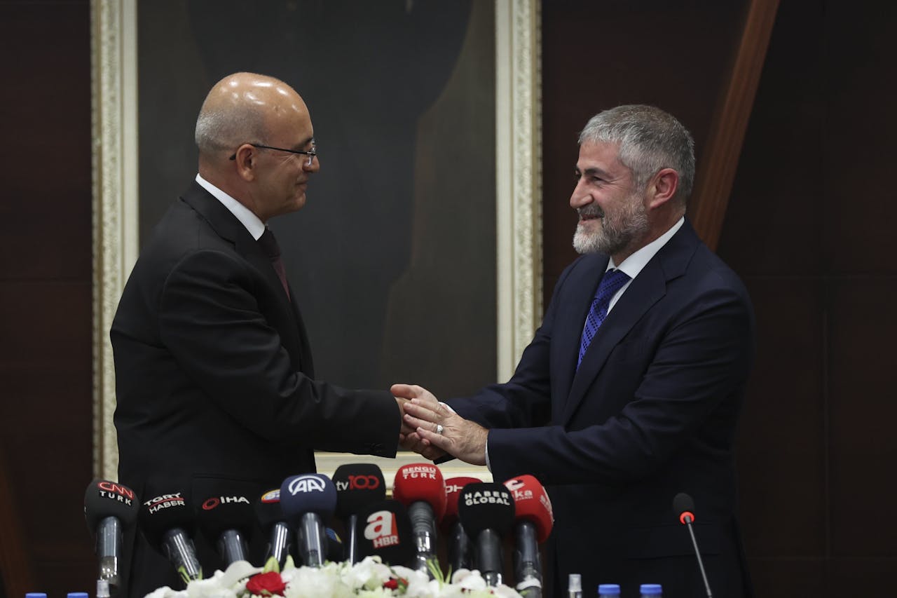 De nieuwe Turkse minister van financiën, Mehmet Simsek (op de foto links) schudt de hand van zijn voorganger, Nureddin Nebati.