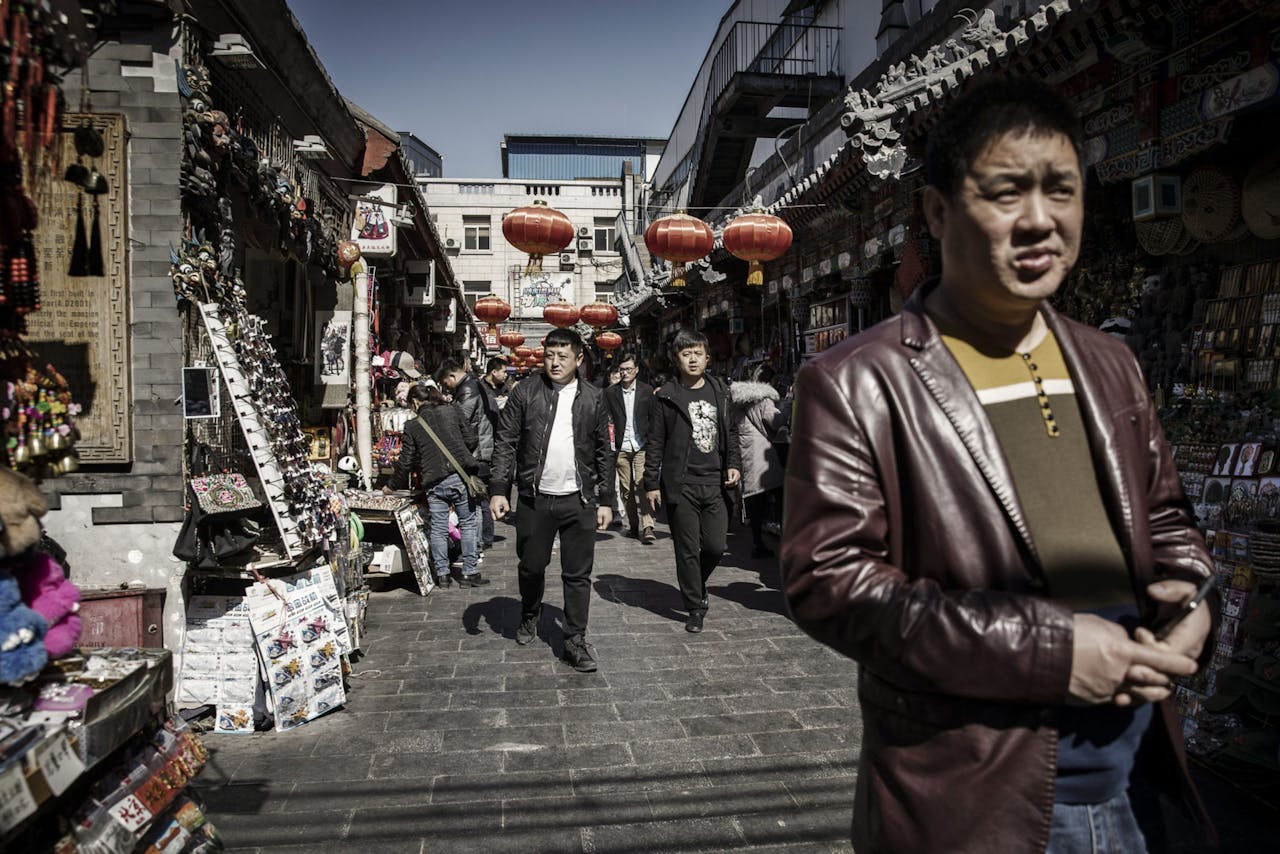 Voetgangers lopen door Wangfujing, een winkelstraat in Beijing.