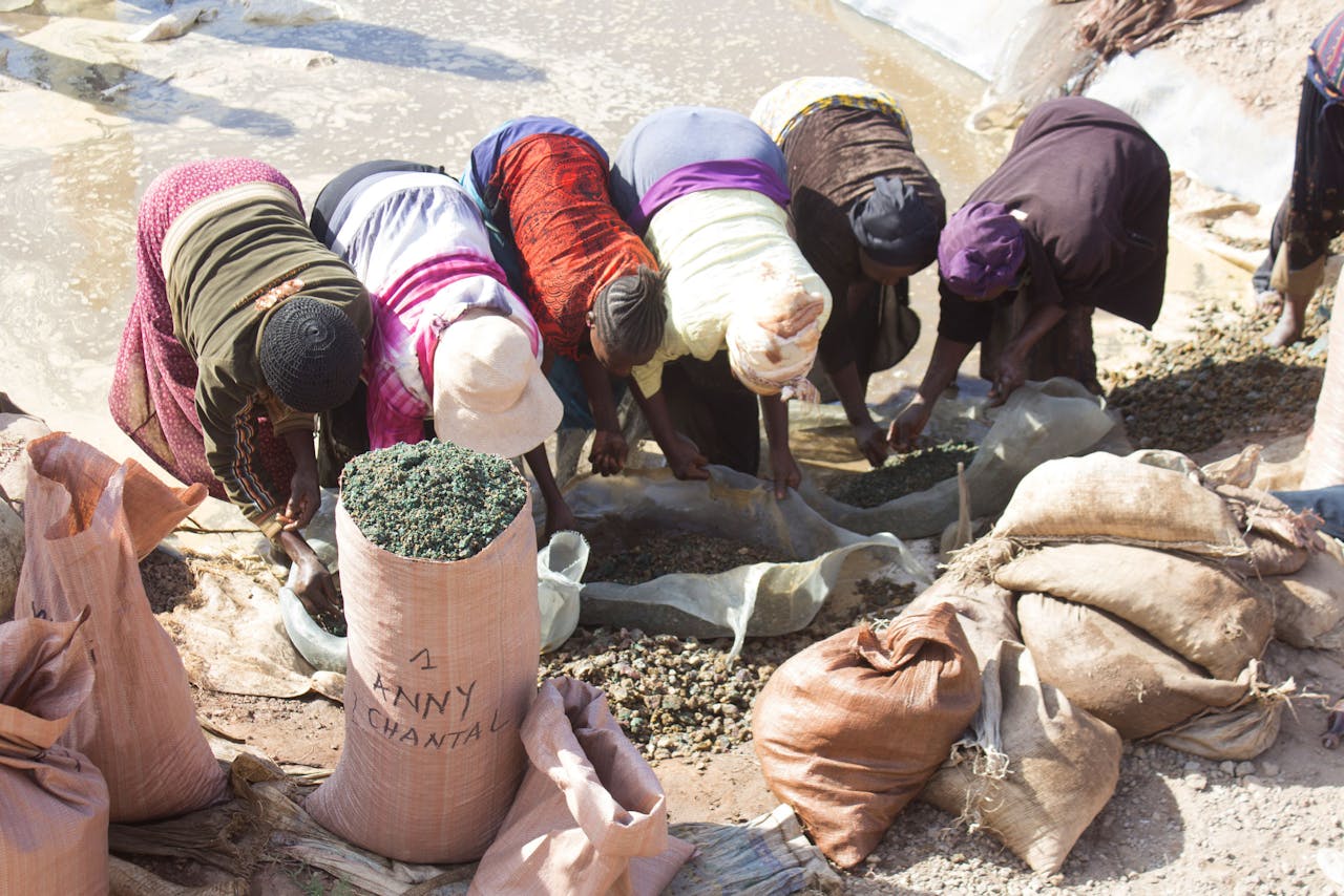 Op de Kamilombe-mijn wast een groep vrouwen de gedolven ertsen.