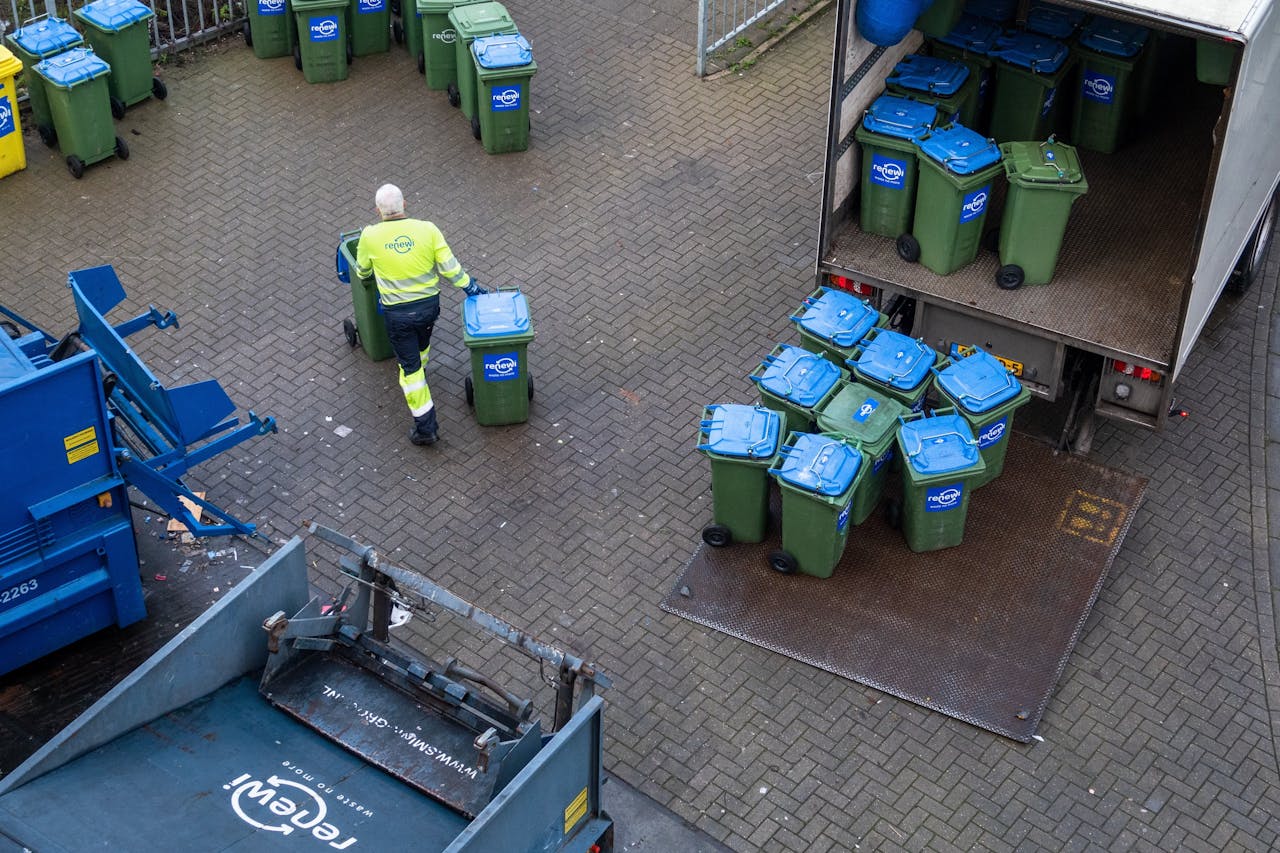 Een medewerker van Renewi met afvalcontainers bij het Centraal Station.