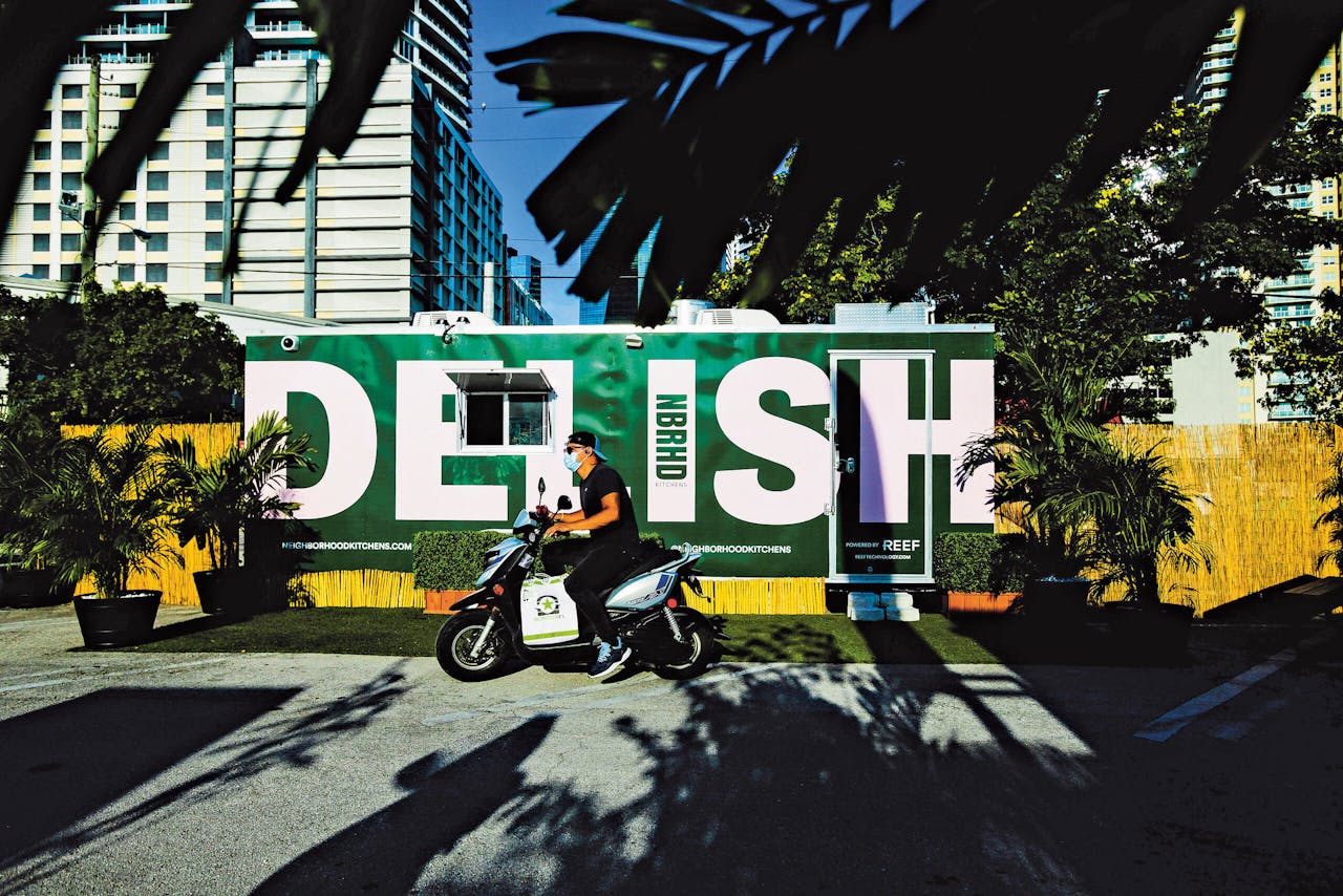 Een bezorger haalt een bestelling op bij een mobiele keuken van Reef in Miami.