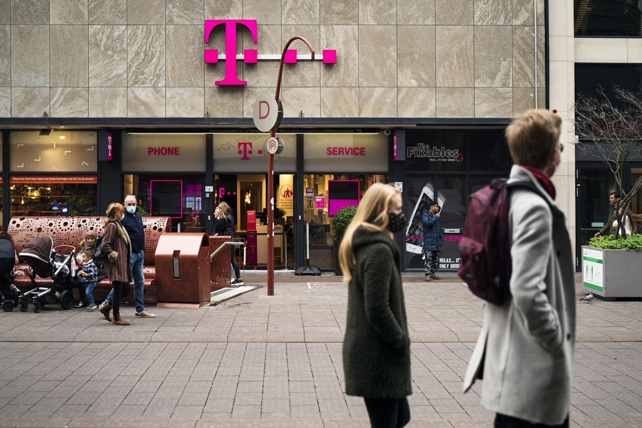 Mensen lopen voorbij een winkel van telefoonprovider T-Mobile in het centrum van Den Haag.
