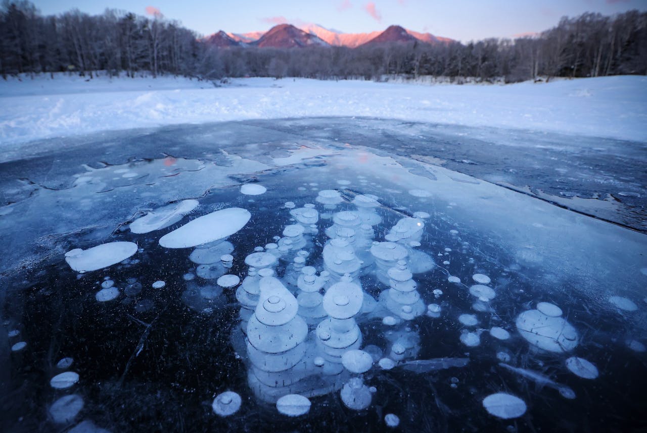 Bellen van methaangas onder het ijs in een meer in het noorden van Japan.